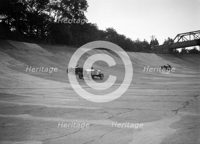 Alvis 17 and Austin 747 cc racing on the banking at Brooklands. Artist: Bill Brunell.