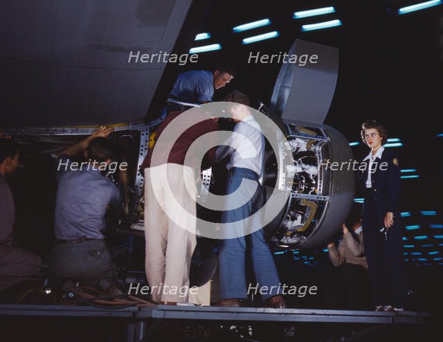 Installing an engine at the Consolidated Aircraft Corporation plant, Fort Worth, Texas, 1942. Creator: Howard Hollem.