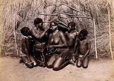 Africa: African women adorning themselves with beads, outside a kraal hut, 19th century. Creator: Unknown.