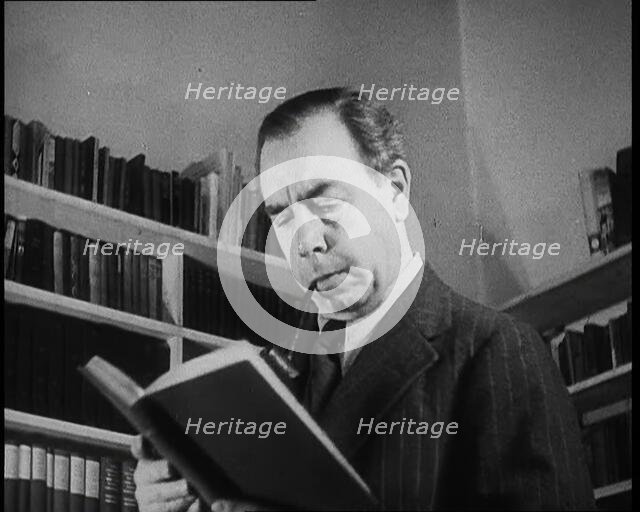J.B. Priestly Reading and Smoking a Pipe, 1930s. Creator: British Pathe Ltd.