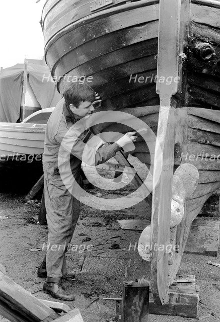 A man cleaning the keel of his sailing boat, Sweden, 1966. Artist: Unknown