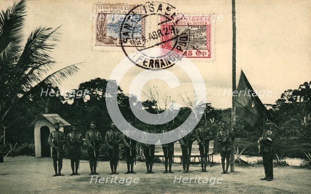 Postcard. St. Elizabeth of Fernando Poo. Flag hoisting by the colonial guard at the Assobla post,…