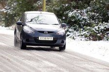 2009 Mazda 2 driving on snowy road Artist: Unknown.