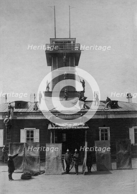 Irkutsk police fire brigade. Exercise with tarpaulins, shields, crowbar and hooks, 1894. Creator: R Prorokov.