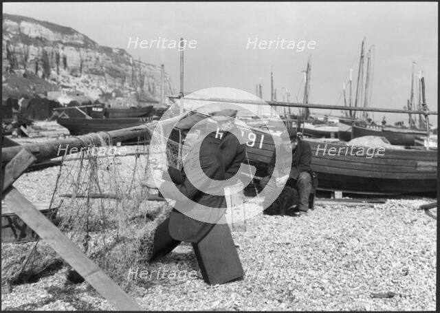 Fishermen mending nets on the beach, Hastings, East Sussex, 1925-1939. Creator: J Dixon Scott.