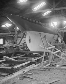 The yawl 'Banzai' in shed at boatyard, 1912. Creator: Kirk & Sons of Cowes.