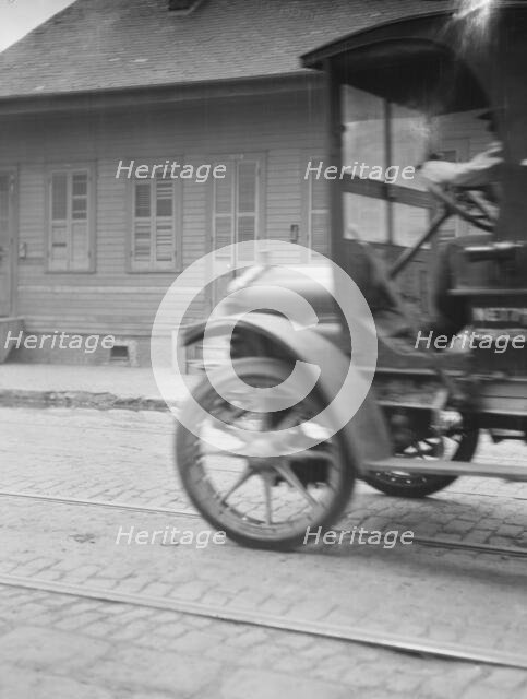 Car driving down a street, New Orleans or Charleston, South Carolina, between 1920 and 1926. Creator: Arnold Genthe.