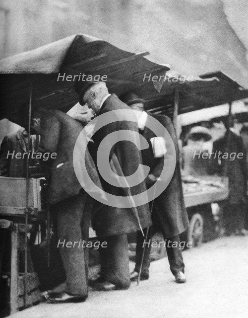 Bookstalls of the Farringdon Road market, London, 1926-1927.Artist: Walter Benington