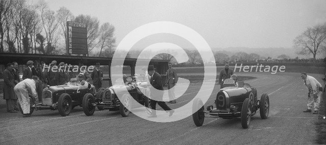 Alfa Romeo and two Bugatti Type 35s on the start line, Donington Park, Leicestershire, 1935. Artist: Bill Brunell.