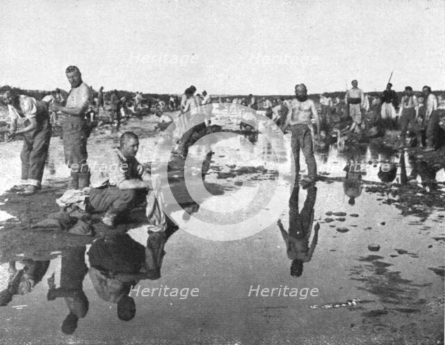 'Tandis que;..et d'autres se baignent sous un chaud soleil, dans l'oued Djedi, pres..., 1917. Creator: Unknown.