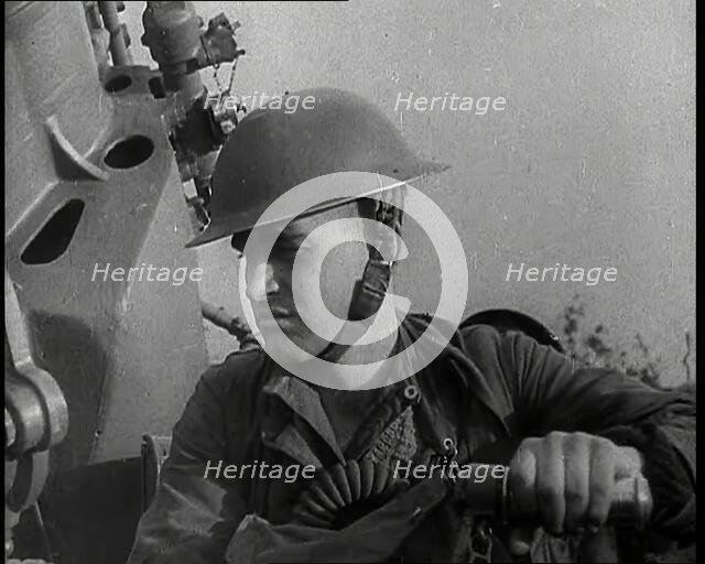 Close up of a Male British Soldier Wearing a Steel Helmet and Sitting Next to an Anti-Air..., 1939. Creator: British Pathe Ltd.