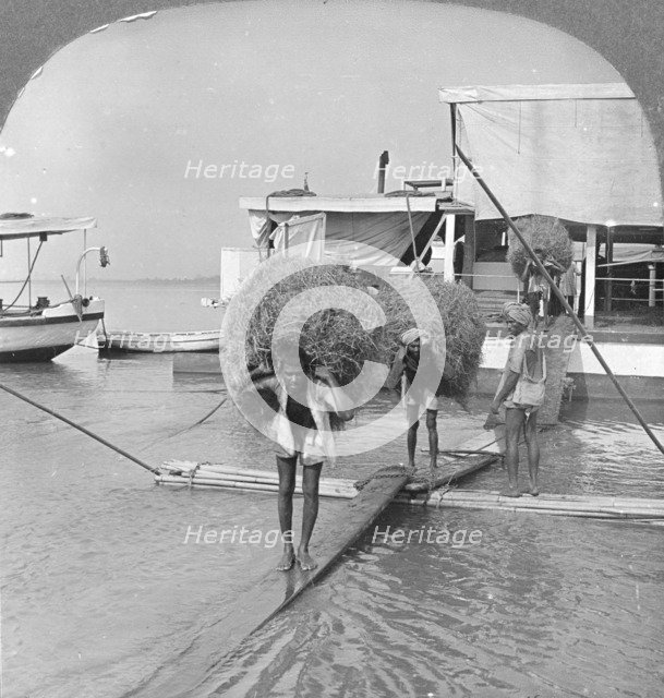 Unloading a vessel on the Irrawaddy River, Burma, 1908. Artist: Stereo Travel Co
