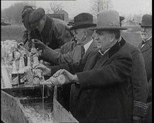 Prohibition Scenes in the United States of America. Men Pouring Away Bottles of Beer Into..., 1920. Creator: British Pathe Ltd.