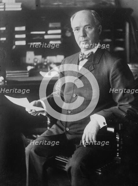 J.D. Archbold, seated holding paper, 1911. Creator: Bain News Service.