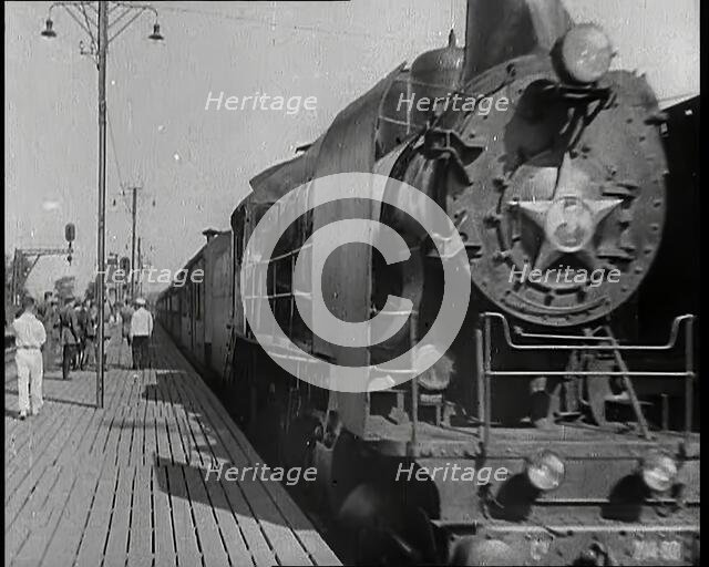 A Train Pulling Into a Station as Assorted Military Men Are Standing on the Platform, 1939. Creator: British Pathe Ltd.