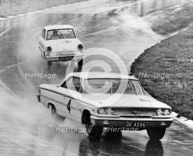 Ford Galaxie, J.Sears, leads Ford Anglia in wet at Brands Hatch 1963. Creator: Unknown.
