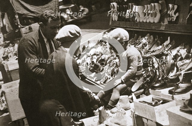 A woman from Harlem buys a pair of shoes for her child, New York, USA, c1920s-c1930s. Artist: Unknown