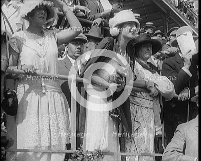 A Large Crowd of Civilians Wearing Smart Outfits and Hats Watching a Horse Race, 1920. Creator: British Pathe Ltd.