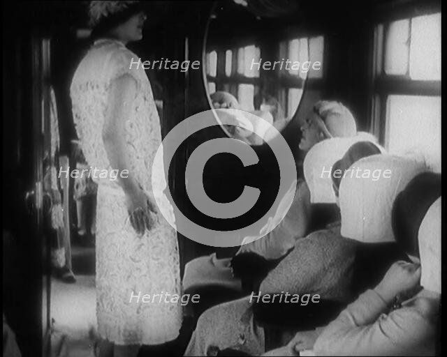 Female Civilian Wearing a Dress and Hat Modelling in Front of a Small Audience Inside a..., 1920. Creator: British Pathe Ltd.
