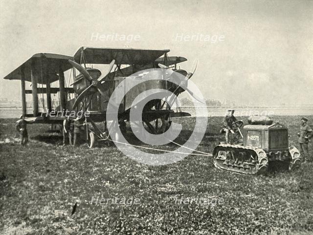 'A Small Motor Tractor Getting a Huge R.A.F. Bombing Machine into Position...', (1919).  Creator: Unknown.