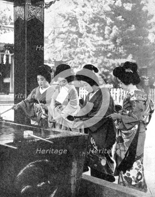 Japanese women washing their hands prior to entering a temple, 1936.Artist: Sport & General