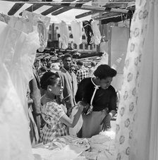 Two women looking at a stall in the Petticoat Lane Market, Whitechapel, London, c1946-c1959. Artist: John Gay