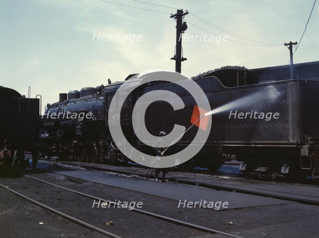 Cleaning an engine near the roundhouse, C. M. St. P. & P. R.R., Bensenville, Ill., 1943. Creator: Jack Delano.