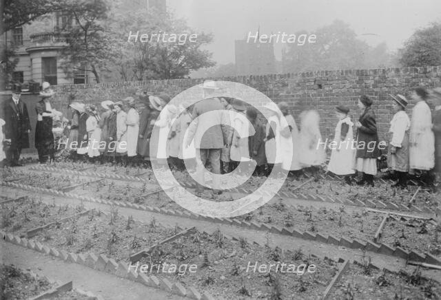Lady Henry and T.P. O'Connor distribute cabbages, 1913. Creator: Bain News Service.