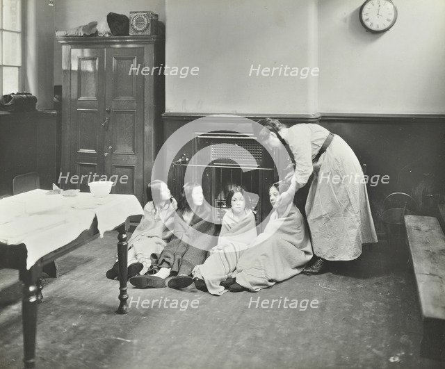 Girls drying their hair by the fire after a bath, Chaucer Cleansing Station, London, 1911. Artist: Unknown.