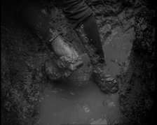 The Legs and Boots of a Male French Soldiers as He is Standing in a Water-Logged Muddy Trench, 1939. Creator: British Pathe Ltd.