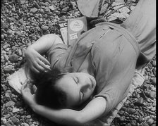 A Young Woman Lying on the Beach at  Brighton With Her Eyes Closed With a Two Books to the..., 1939. Creator: British Pathe Ltd.