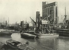 "Factories, Refineries, Granaries Grow Thick" Ship Discharging Grain by Floating Pneumatic...', 1937 Creator: J Dixon-Scott.