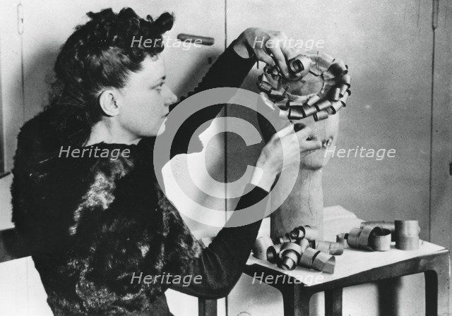 Woman making a hat from wood shavings, German-occupied France, April 1941. Artist: Unknown