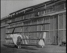 A Male Pilot Getting Into an Early Seven Winged Plane, 1922. Creator: British Pathe Ltd.