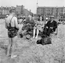 A child photographs his mother and grandparents on the beach, Blackpool, c1946-c1955. Artist: John Gay