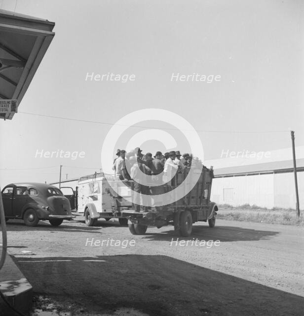 Labor contractor's truck with gang of pea pickers pulled up for gas, Westley, California, 1939. Creator: Dorothea Lange.