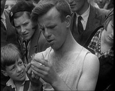 A Man Eating a Glass as the Crowd Behind Him Winces, 1921. Creator: British Pathe Ltd.