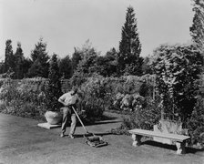 Gardener pushing lawn mower, posed to illustrate Rudyard Kipling's poem The Glory of the Garden,1917 Creator: Frances Benjamin Johnston.