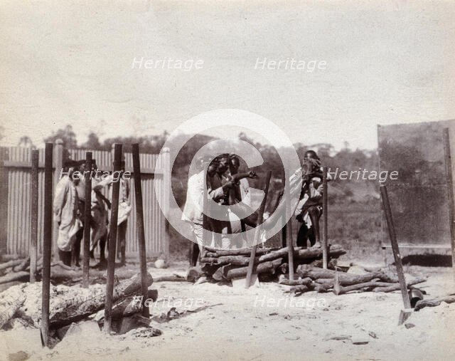 A group of men lower the body of a dead man on to a pyre of logs prior to a Hindu...,  1896/1897. Creator: Unknown.