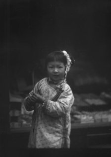 Young girl walking down the street, looking into the camera, Chinatown, San Francisco, c1896-c1906. Creator: Arnold Genthe.