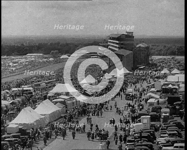 Large Crowd Sitting Outside with Cars and Tents, 1933. Creator: British Pathe Ltd.