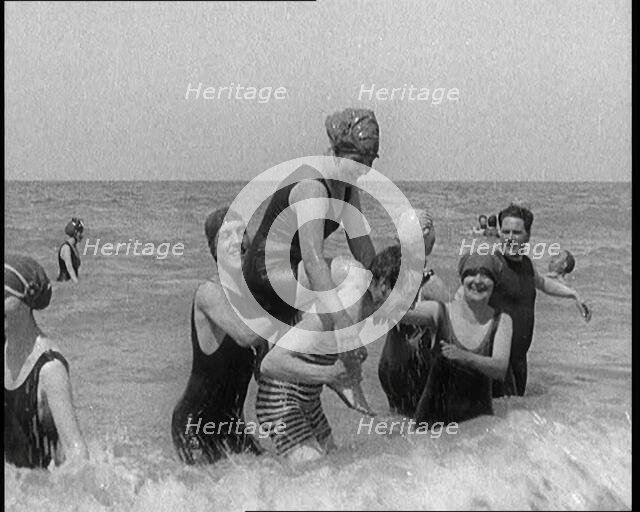 Group of Four Female Civilians and One Male Civilian in Bathing Suits Playing in the Sea..., 1924. Creator: British Pathe Ltd.
