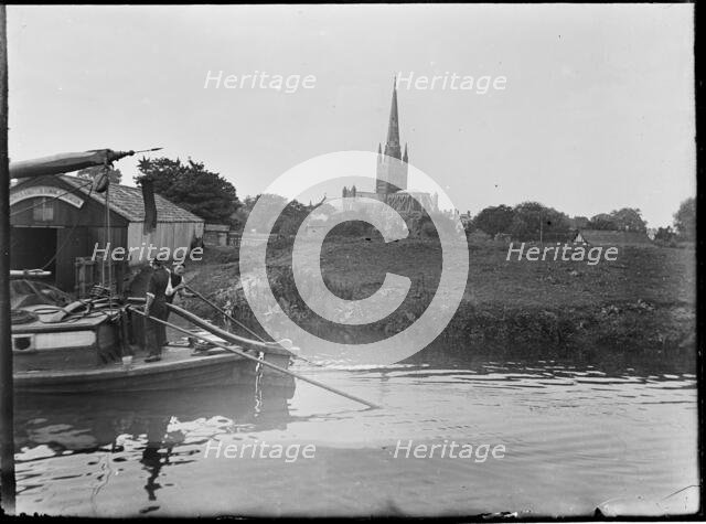 Norwich Cathedral from Pull's Ferry, with men on a boat in the foreground, Norwich, Norfolk, 1920-38 Creator: George R Long.