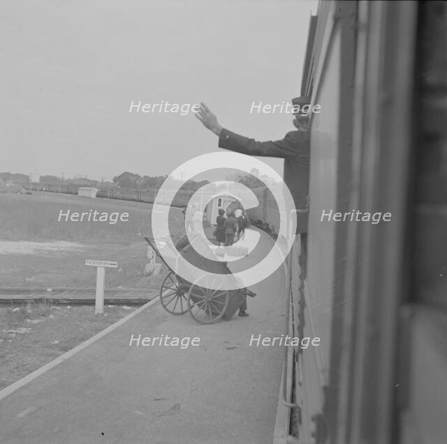 Trainman signalling from a "Jim Crow" coach, Saint Augustine, Florida, 1943. Creator: Gordon Parks.