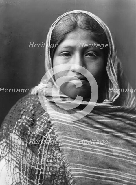 Yaqui girl, head-and-shoulders portrait, facing front, with striped shawl draped around..., c1907. Creator: Edward Sheriff Curtis.