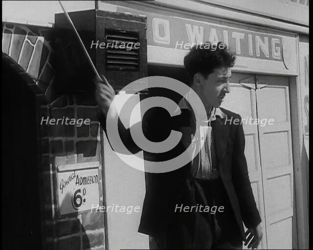 A Young Man in a Suit With an Open-Necked Shirt and Holding a Stick in One Hand is Drumming..., 1938 Creator: British Pathe Ltd.