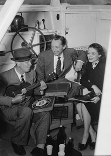 Portrait of Cliff Edwards, Betty Brewer, and Frank..., Ukelele Lady (yacht), Hudson River, NY, 1947. Creator: William Paul Gottlieb.