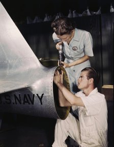 Mrs. Virginia Davis, a riveter in the assembly and repair department of the Naval Air Base..., 1942. Creator: Howard Hollem.