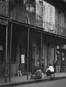 Women on a covered sidewalk, New Orleans, between 1920 and 1926. Creator: Arnold Genthe.