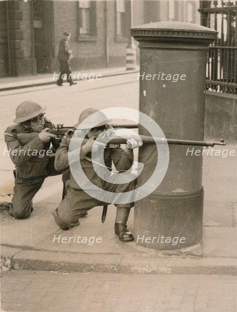 The Home Guard find cover behind a pillar box during a enemy engagement rehearsal, 1941. Artist: Unknown